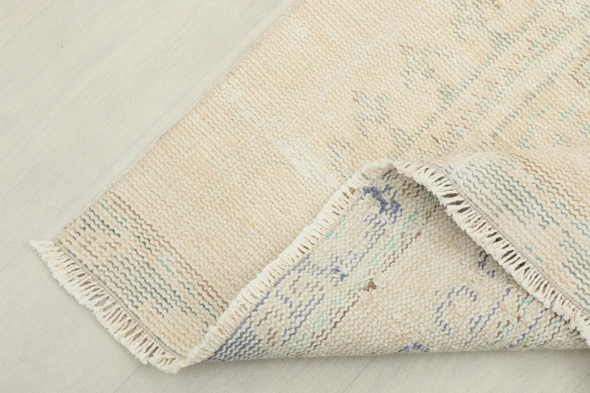 View of the rug's underside, showing the cotton foundation and hand-knotted construction