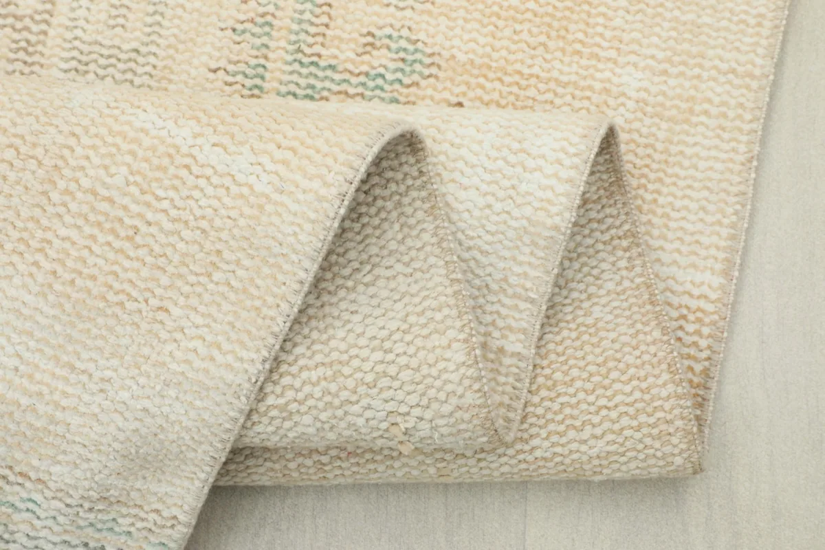 Close-up of the rug's edge and fringe, showing the natural wear and hand-finished details
