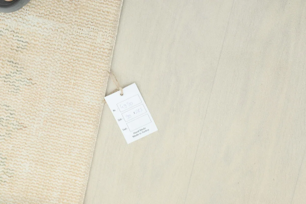 Overview of the rug's edge with a product tag, indicating its authenticity and origin