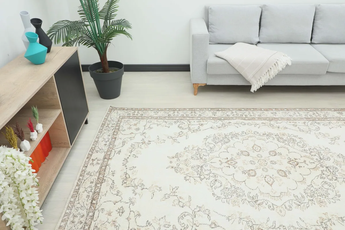 View of the rug in a room, showing its scale relative to a sofa and side cabinet.
