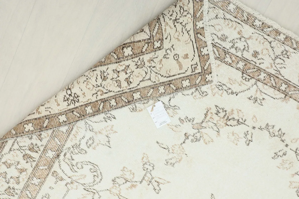 Close-up of the back of the rug, showing the knotting structure and cotton foundation.