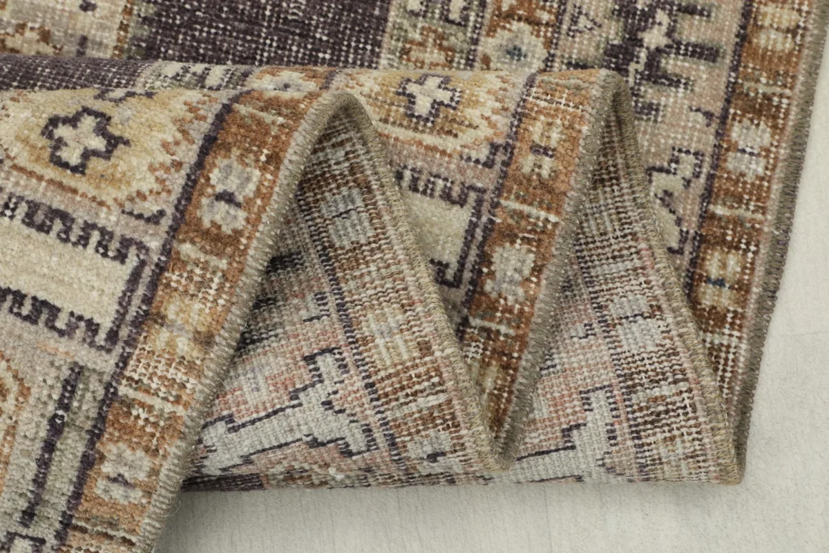 Close-up of the rug's edge, folded to show the thickness and construction of the vintage wool material.
