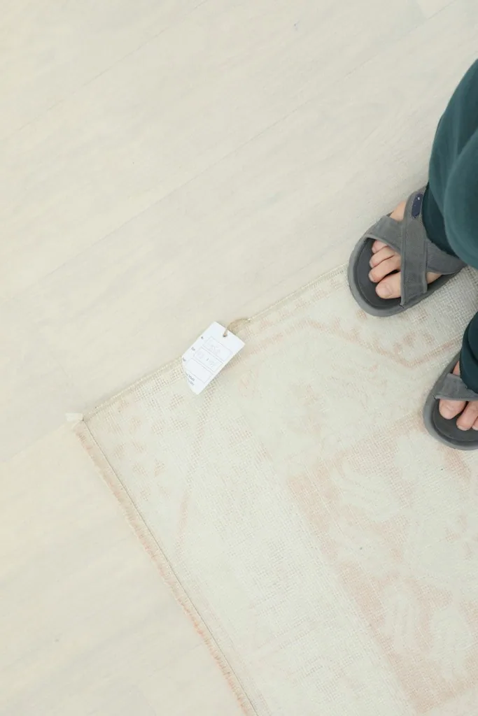 View of the rug with a size tag next to feet, indicating scale
