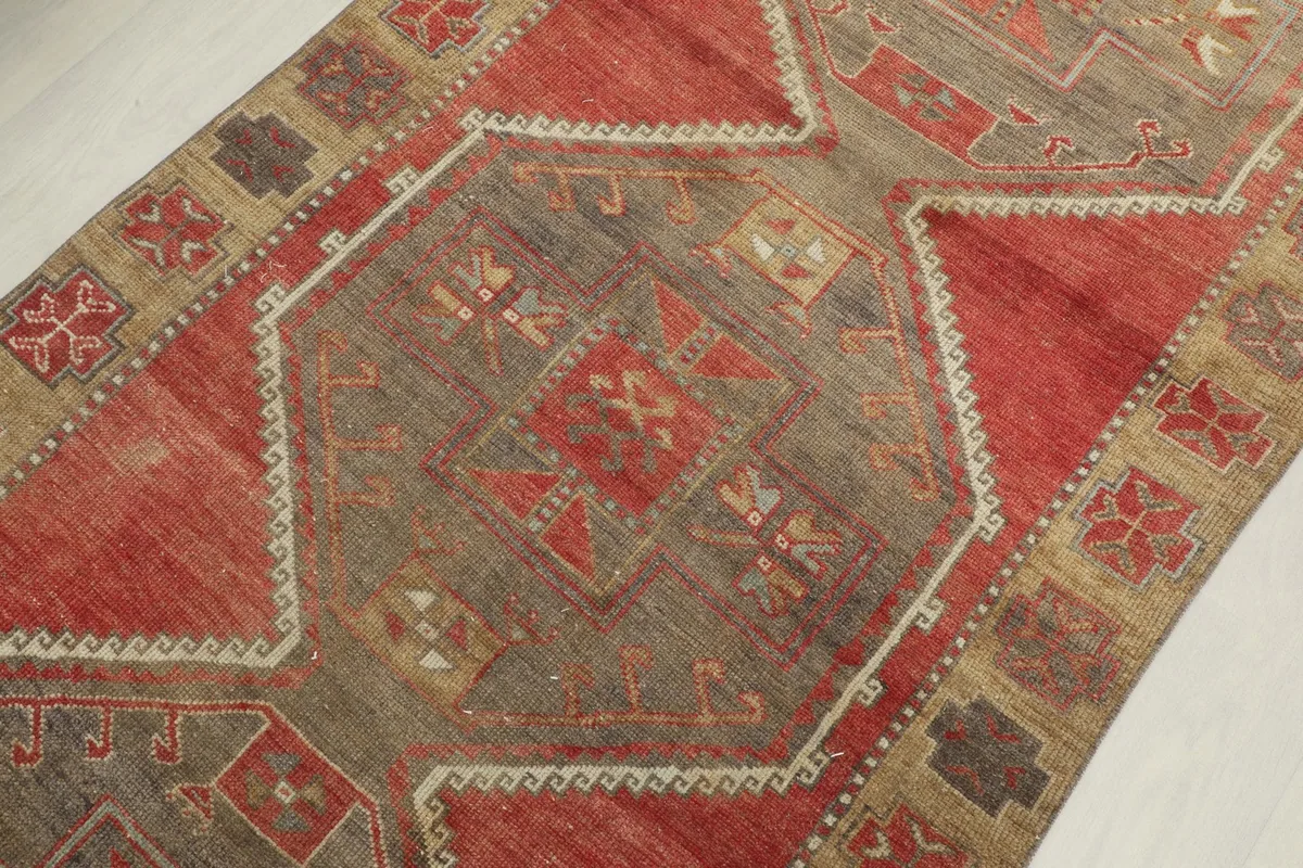 Detailed view of the central geometric motif and surrounding patterns in red, tan, and gray