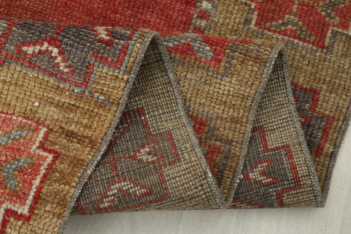 Side view of the rug with a section folded, showcasing the low wool pile
