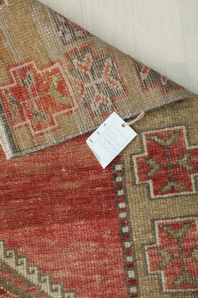 Detail of the rug with an information tag, showing the weave and colors