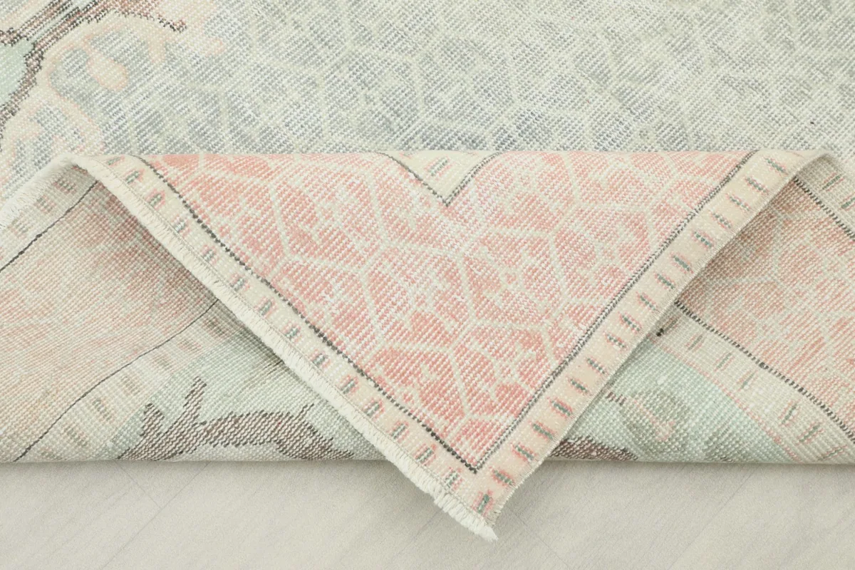 Folded corner of the rug revealing the backside of the rose border and knotting