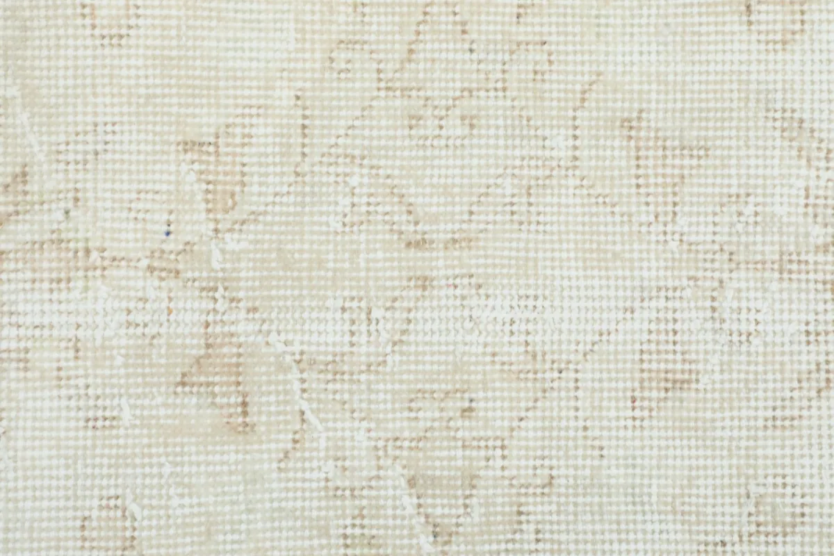 Extreme close-up of the hand-knotted wool pile, showing individual knots and faded colors.