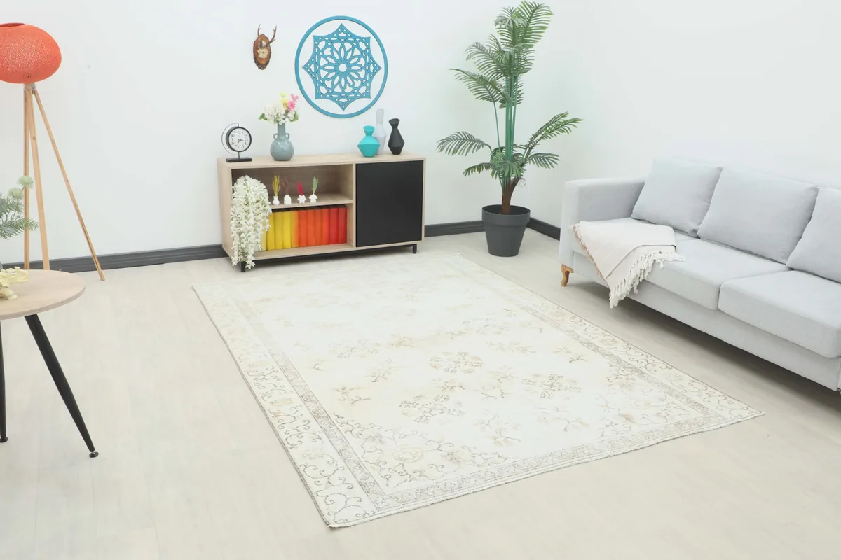 Ivory beige floral rug in a room setting with a light sofa and console table