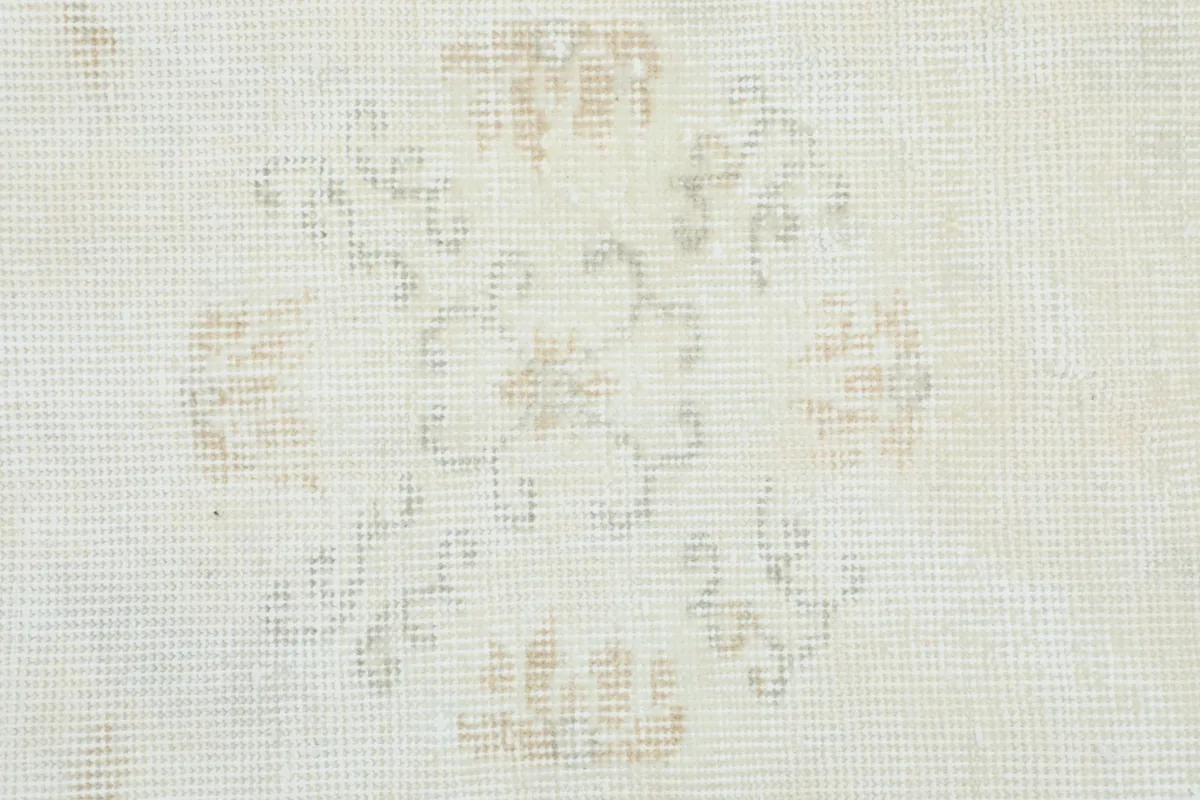 Detailed view of a single floral medallion motif on the ivory rug