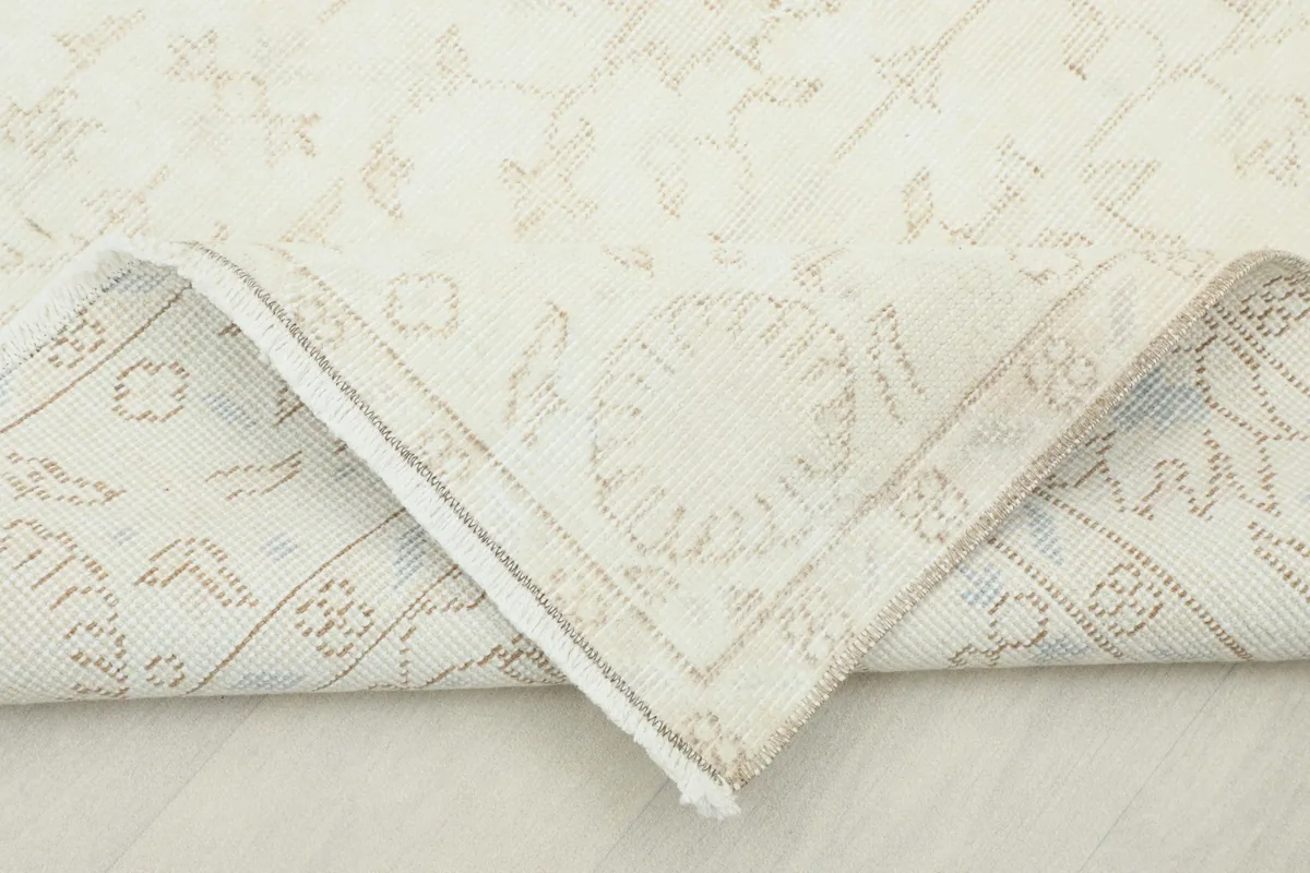 Folded corner of the rug, revealing the cotton foundation and the reverse side.