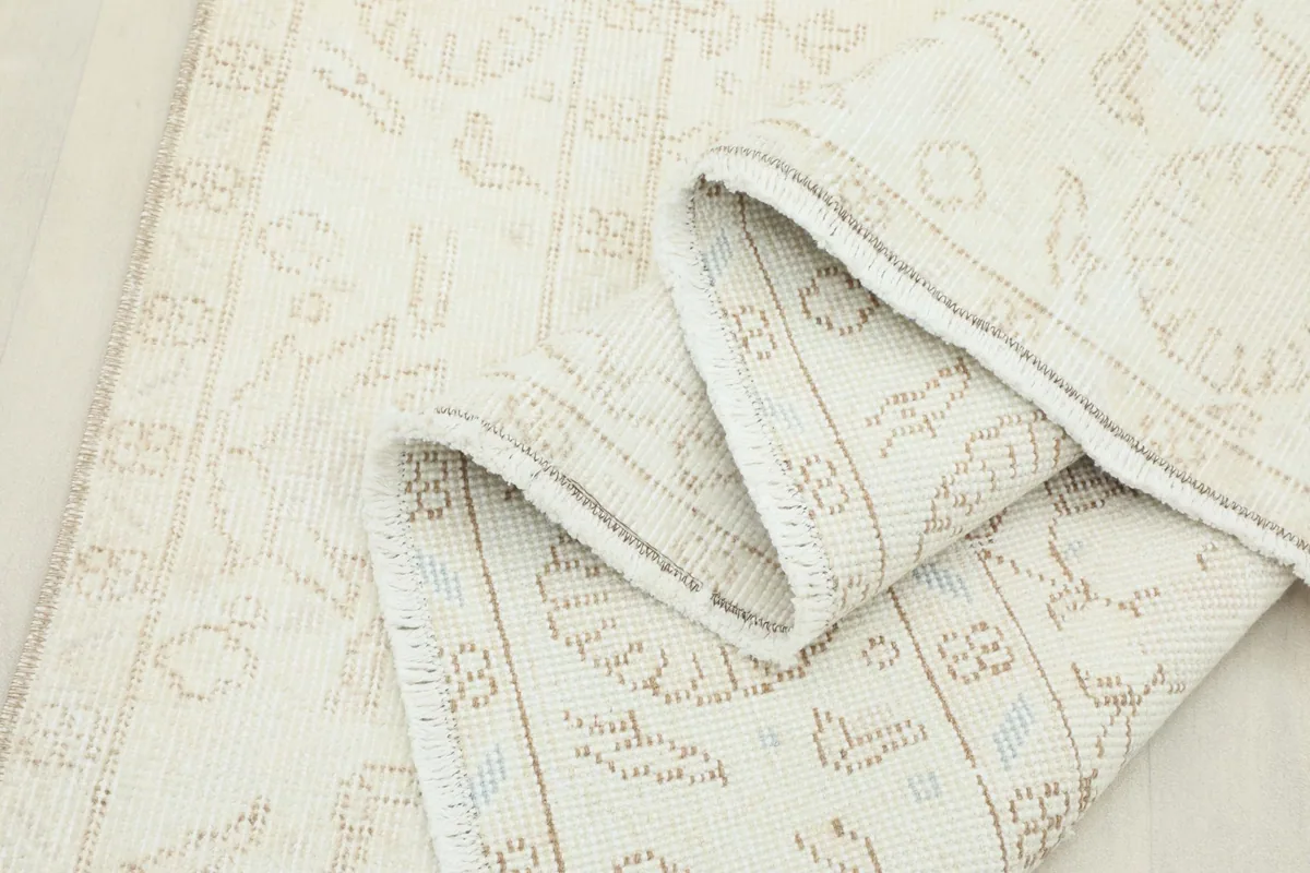 Another folded view of the rug, showing the flexibility and construction of the vintage piece.