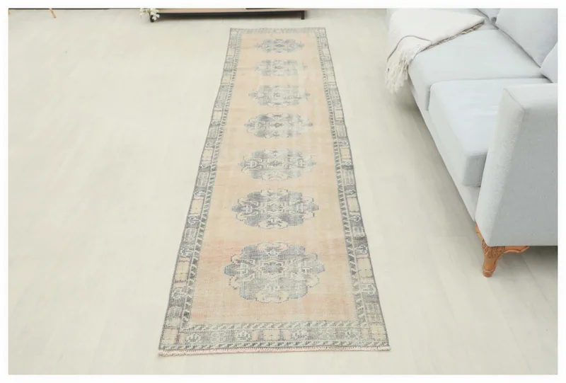 Full top view of the beige and gray vintage Anatolian runner rug on a white background.