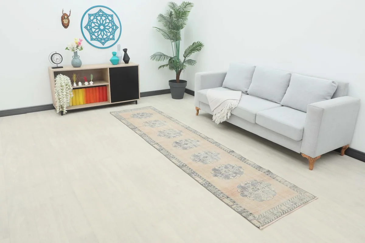 Runner rug displayed in a room setting with a light gray sofa and modern shelving.