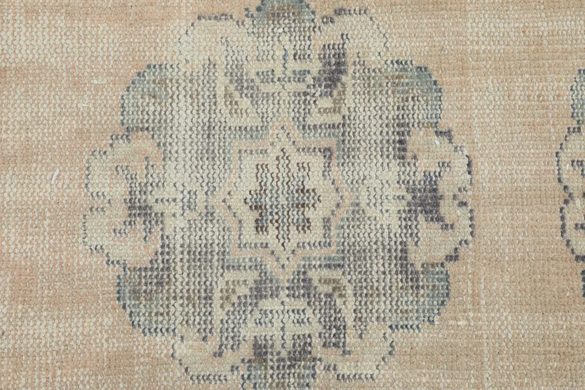 Macro detail of a single geometric medallion, showing the texture and colors of the wool pile.
