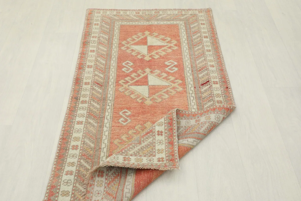 Rug with one corner folded back, displaying the reverse side and the overall pattern