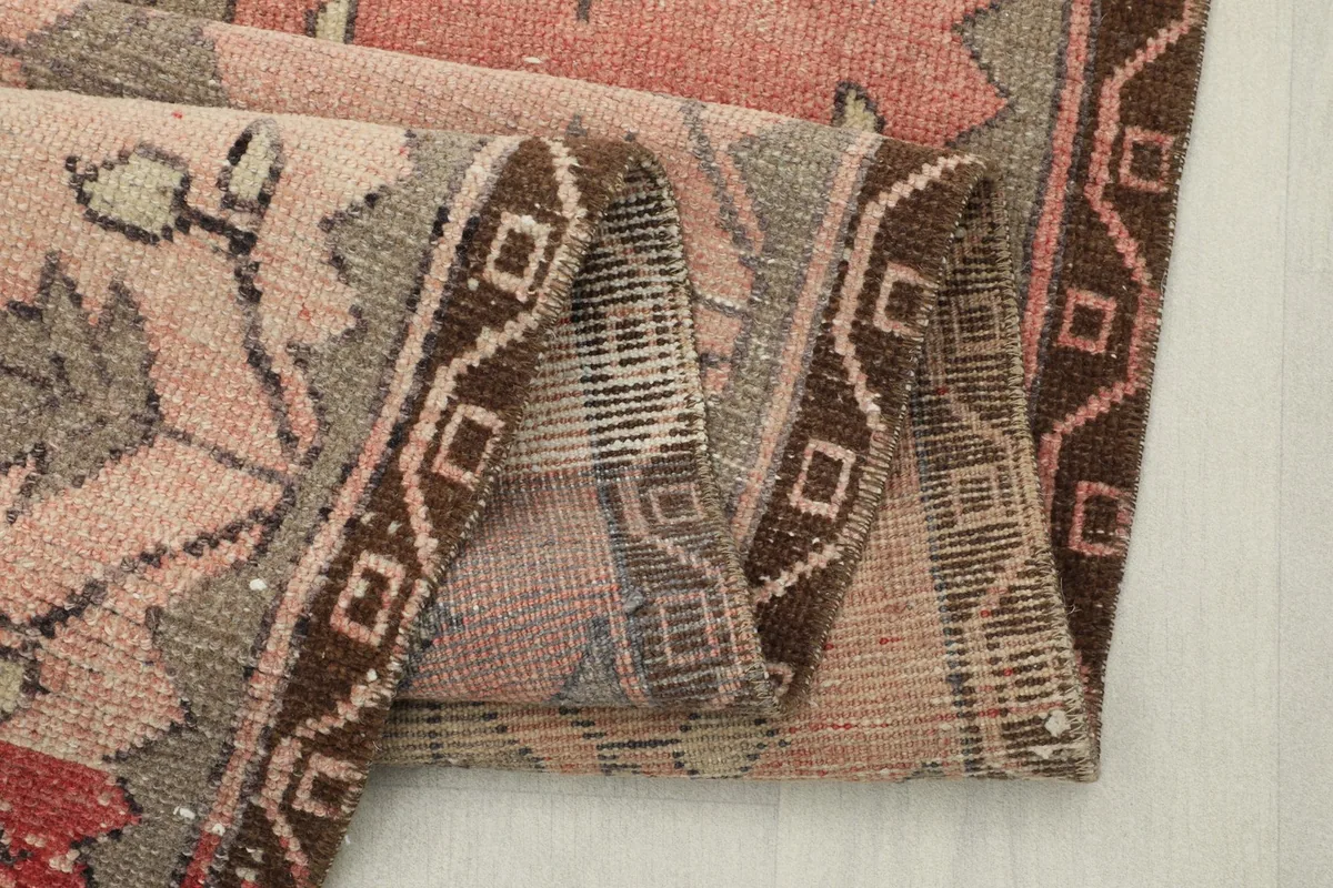 Close-up of the runner rug's edge folded, showing the brown border and construction