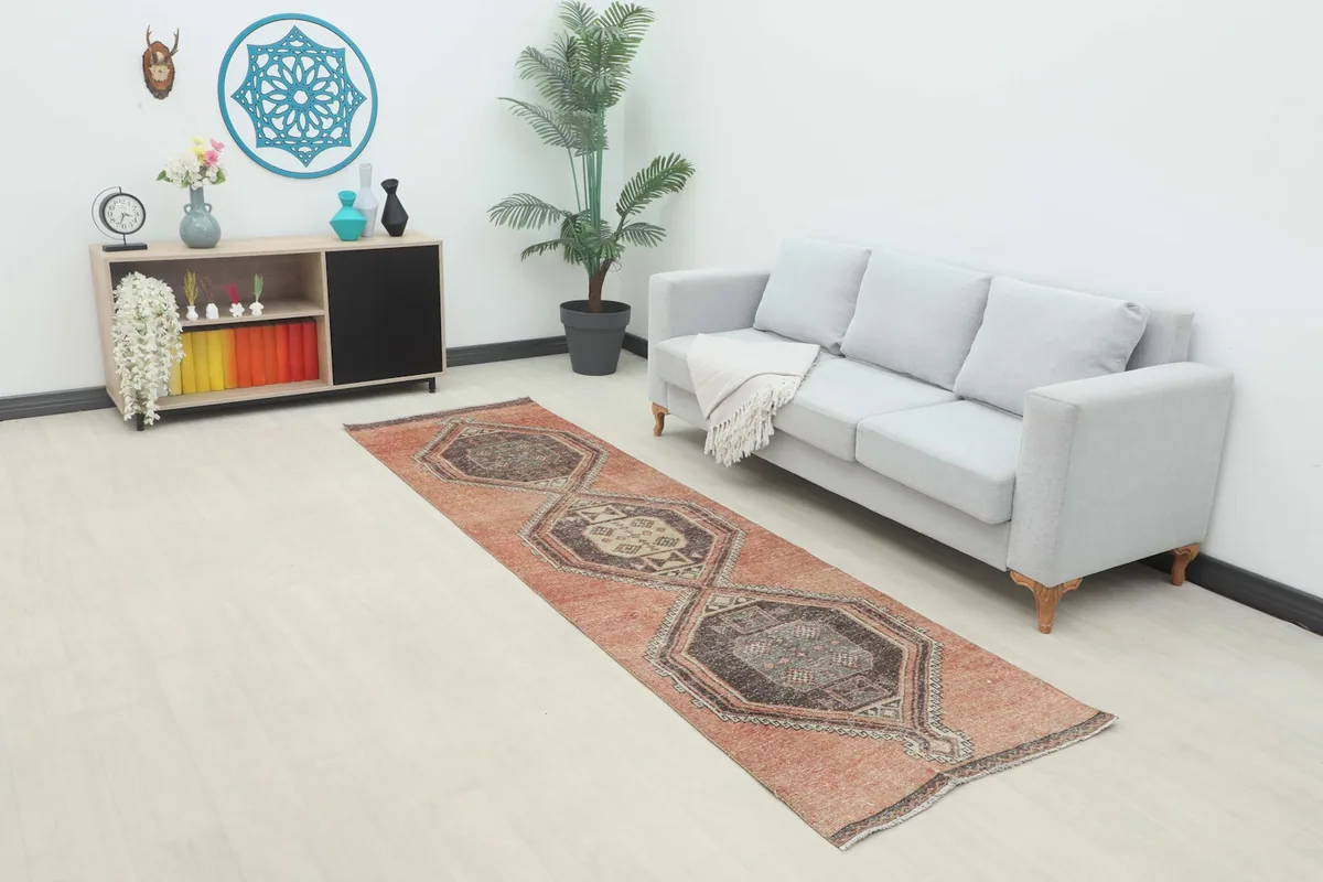 Rust vintage runner rug displayed in a living room setting next to a sofa