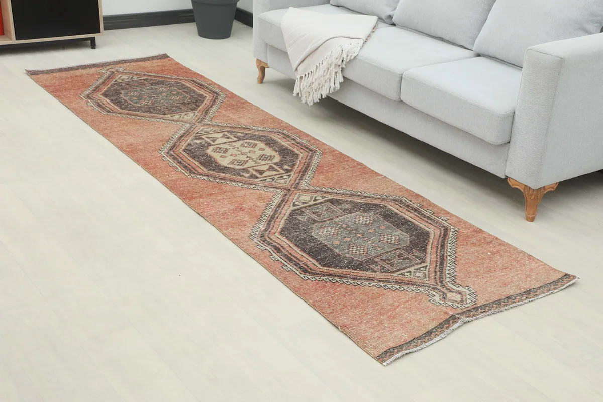 Angled view of the rust runner rug in a room, highlighting its length and placement
