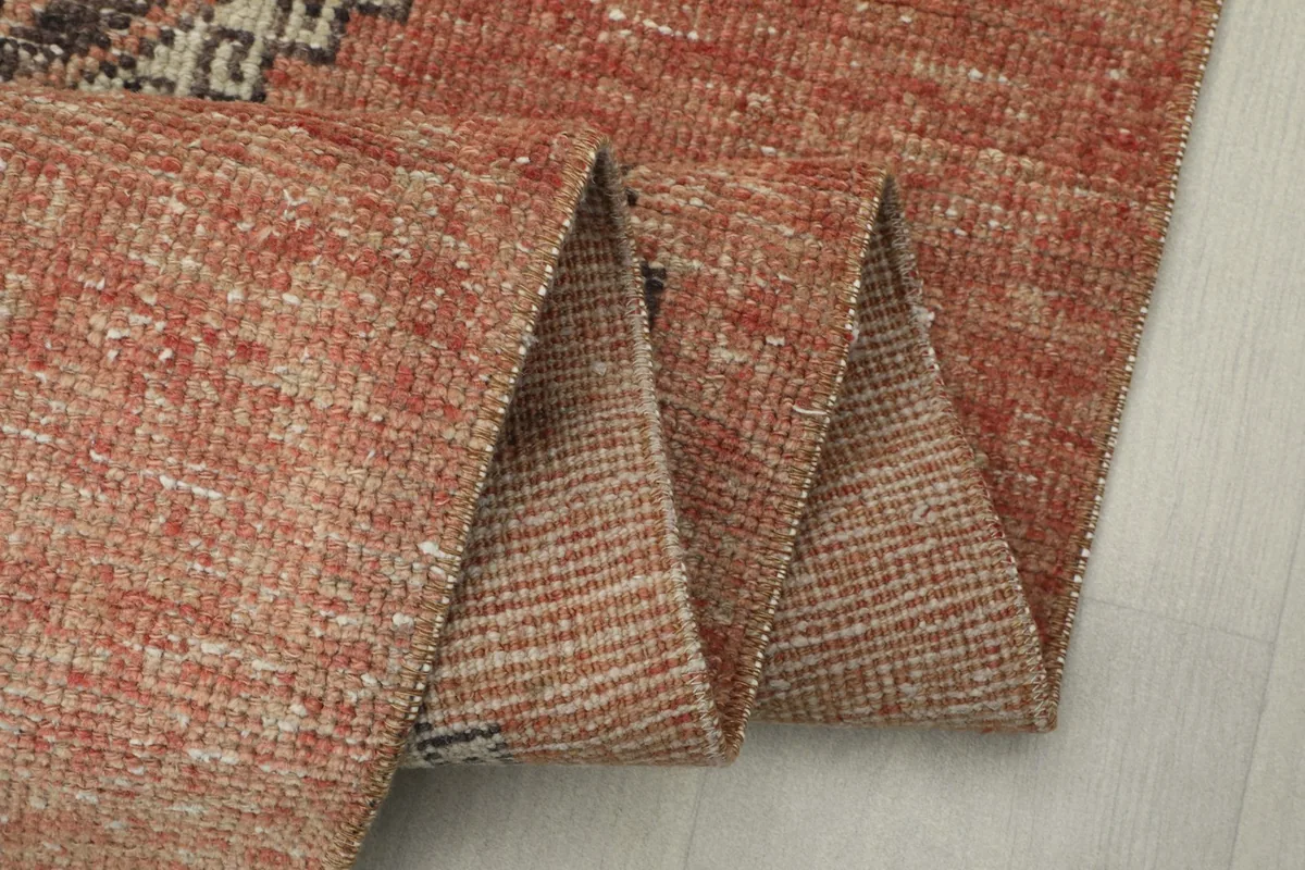 Close-up of the rug's pile and weave where it is folded, showing texture and color variation