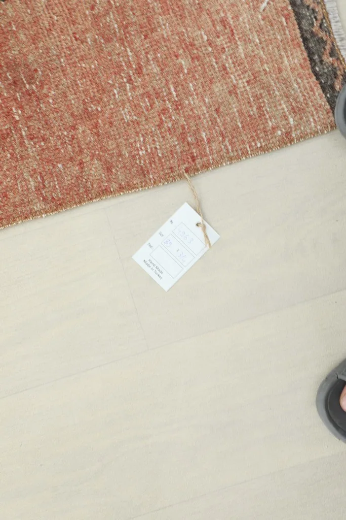 Overhead view showing the product tag on the floor next to the runner rug