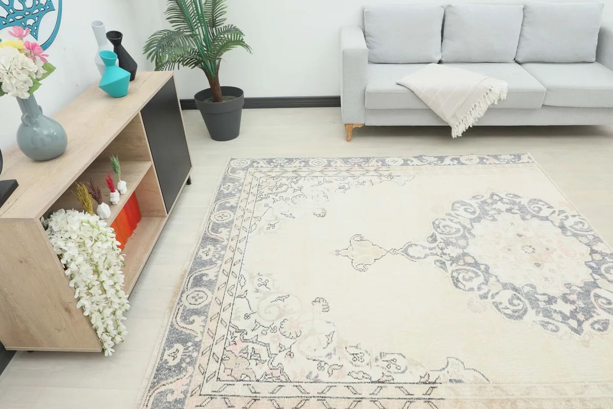 Angle view of the ivory and gray rug complementing a modern living space with a light sofa.
