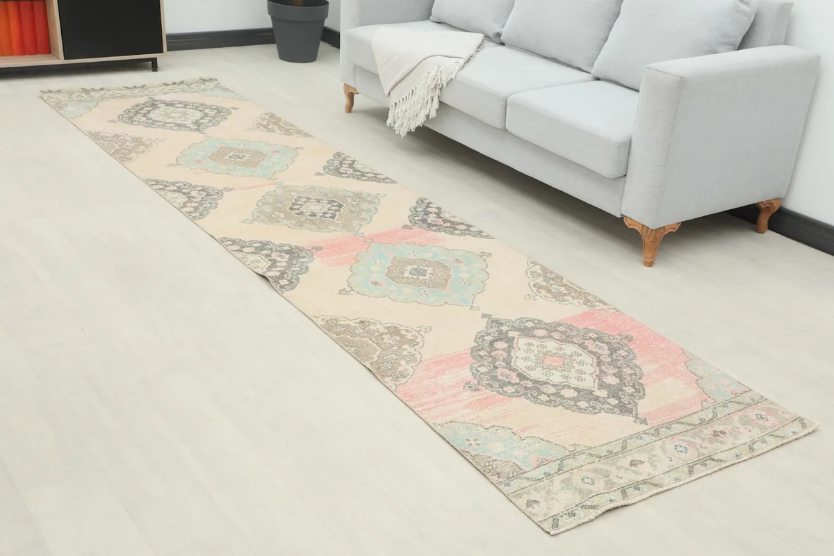 Angle view of the runner rug in a room, highlighting the geometric medallion pattern and distressed areas