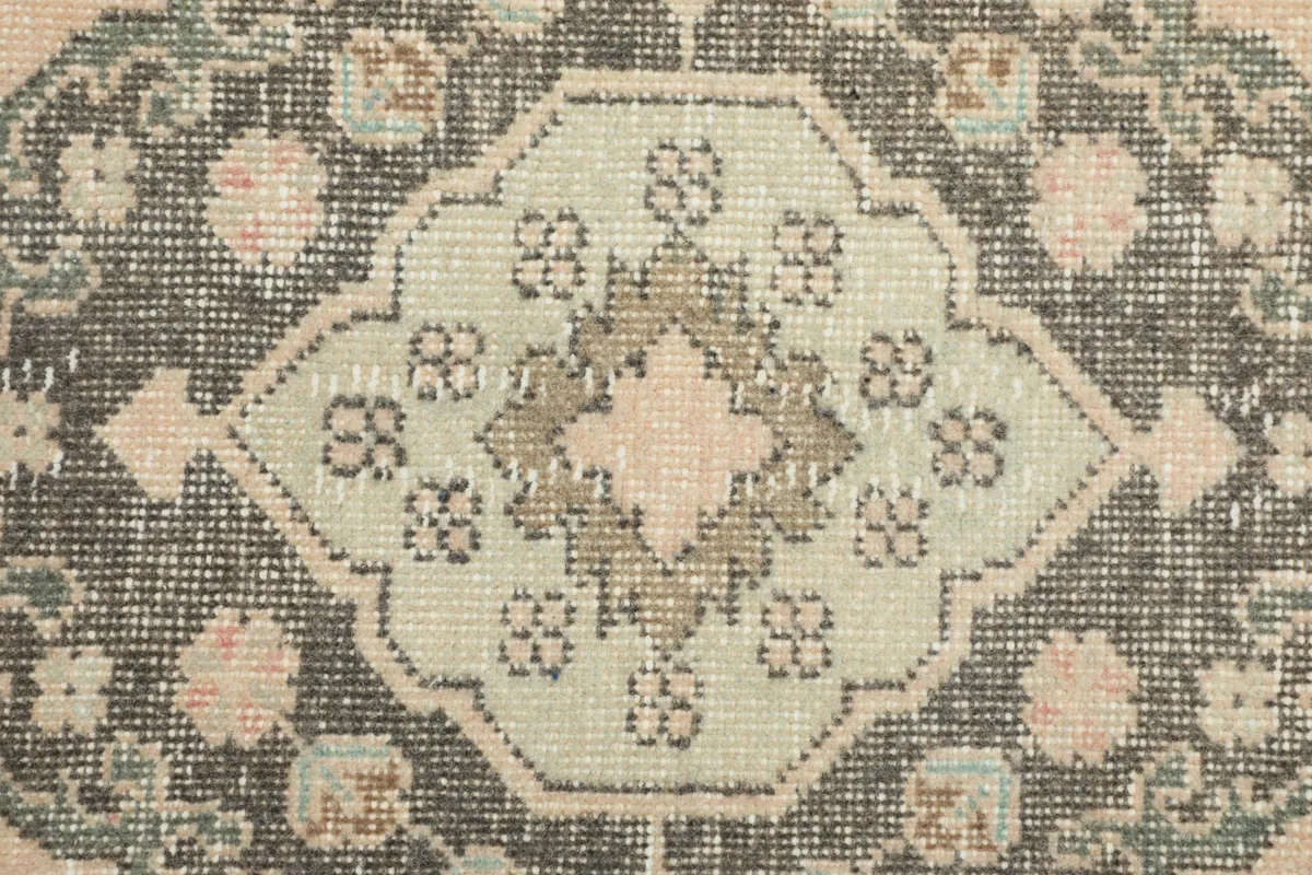 Macro detail of the hand-knotted wool pile, revealing the intricate patterns and subtle color shifts