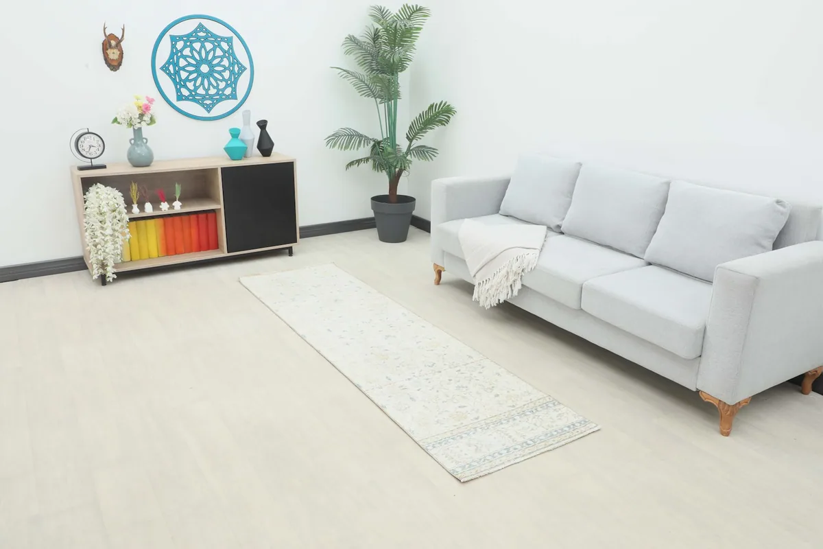 Ivory runner rug displayed in a living room setting, complementing a gray sofa and modern decor.