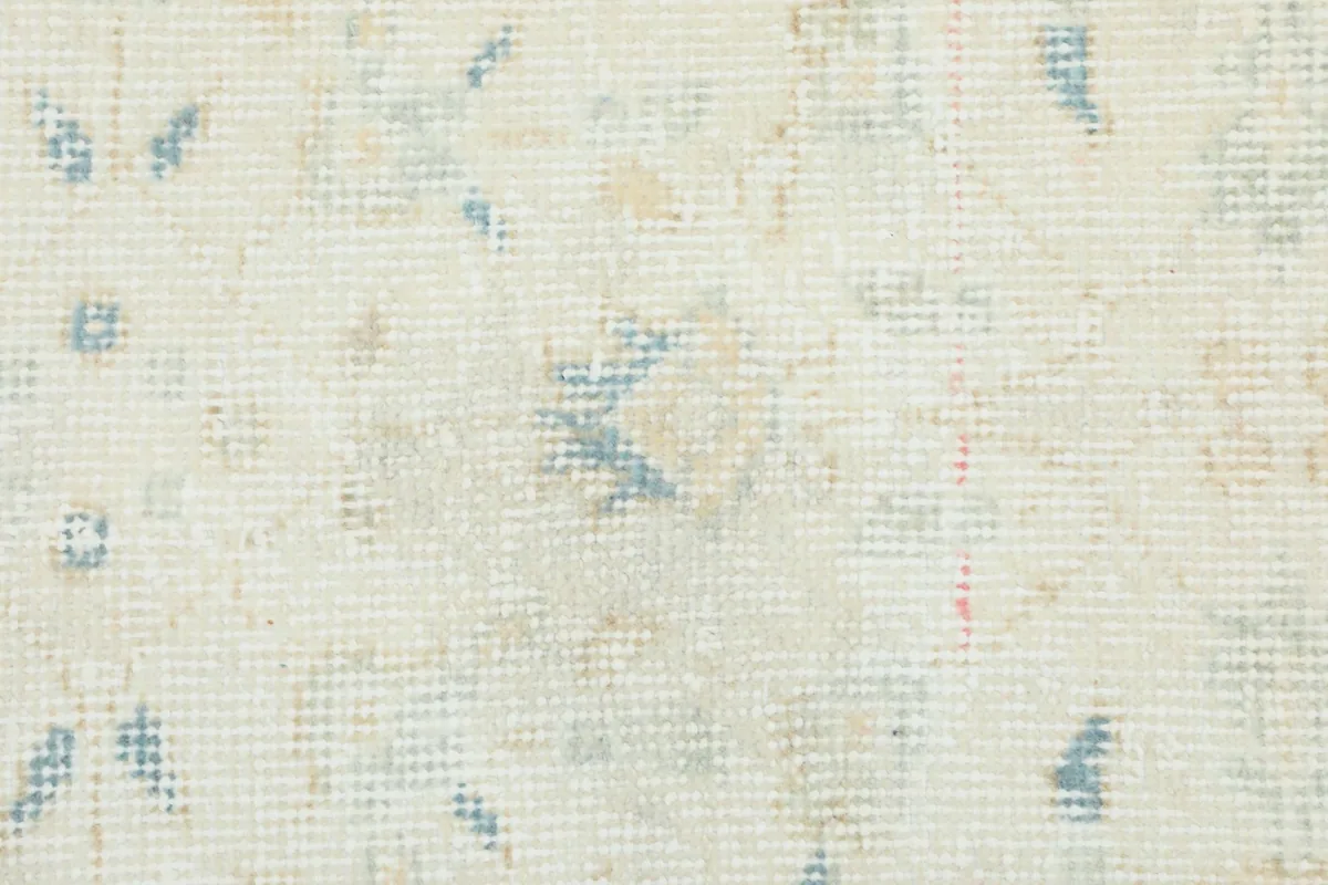 Extreme close-up of the rug's low pile, revealing the hand-knotted texture and fibers.