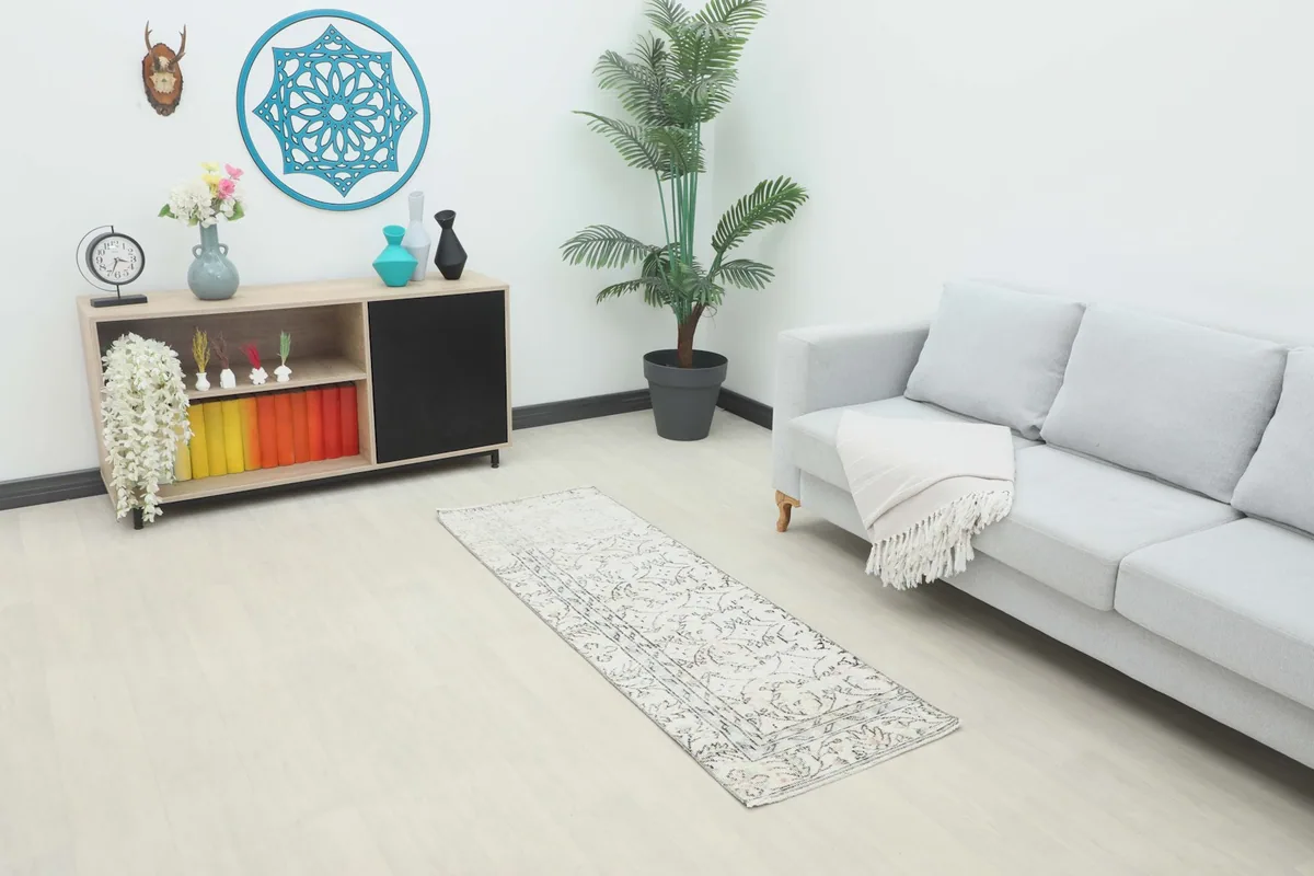 Runner rug in a modern living room setting, showing its scale next to a sofa and cabinet.