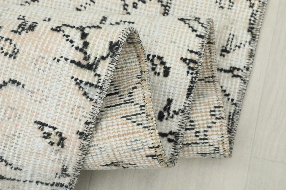 Extreme close-up of the low wool pile and the intricate hand-knotted texture.