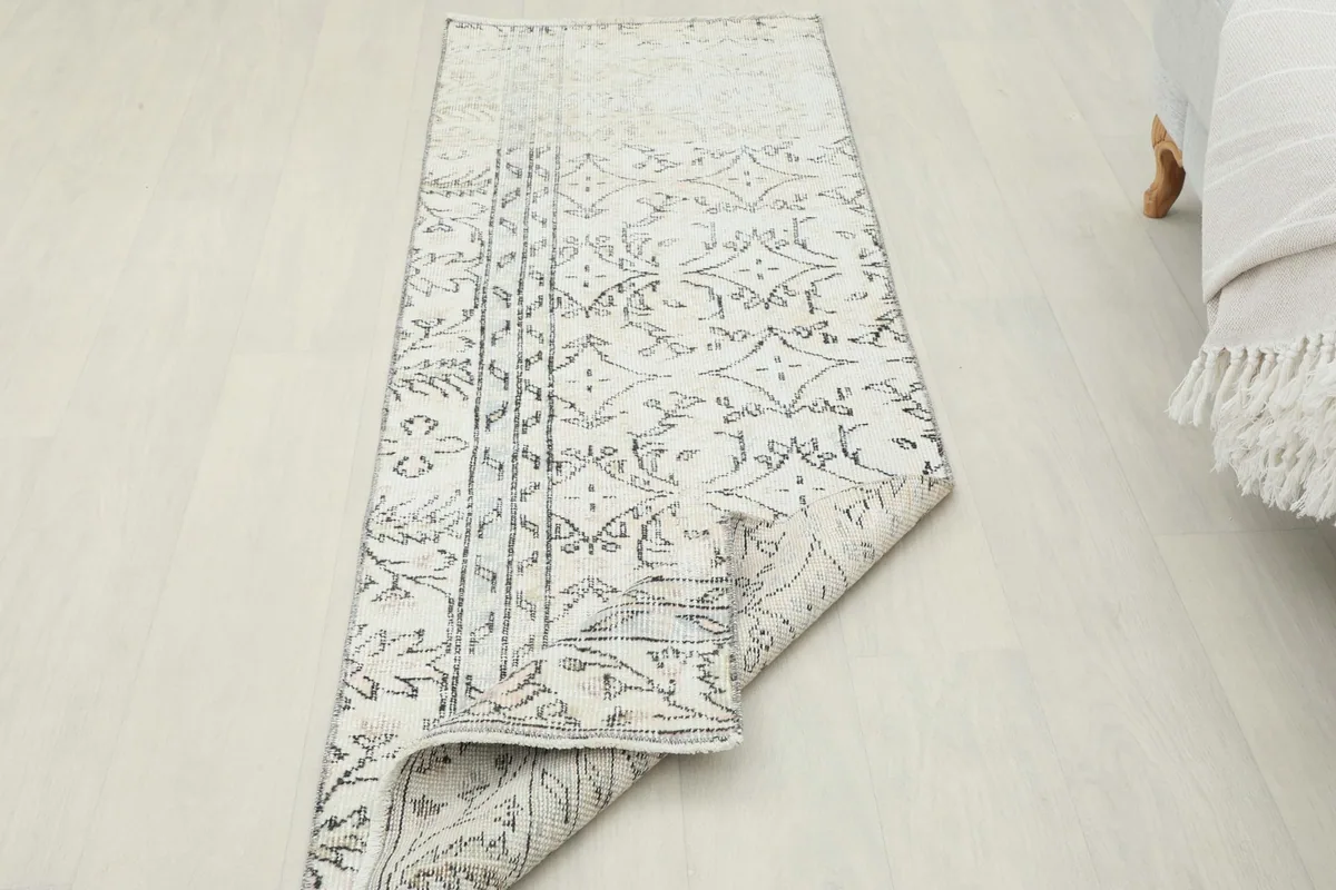Runner rug partially rolled, showcasing its flexibility and the overall pattern.