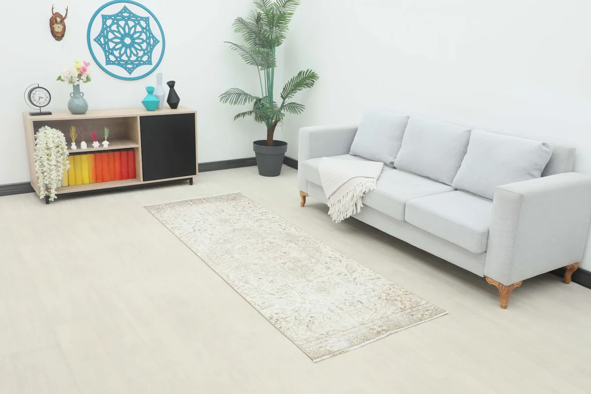 Runner rug in a living room setting, showcasing its dimensions next to a sofa.