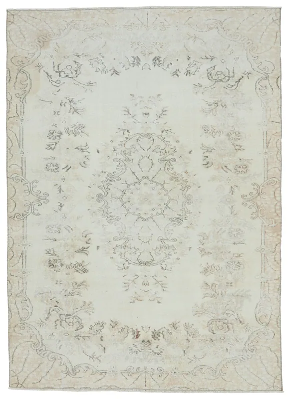 Full overhead view of the ivory and tan floral medallion vintage rug