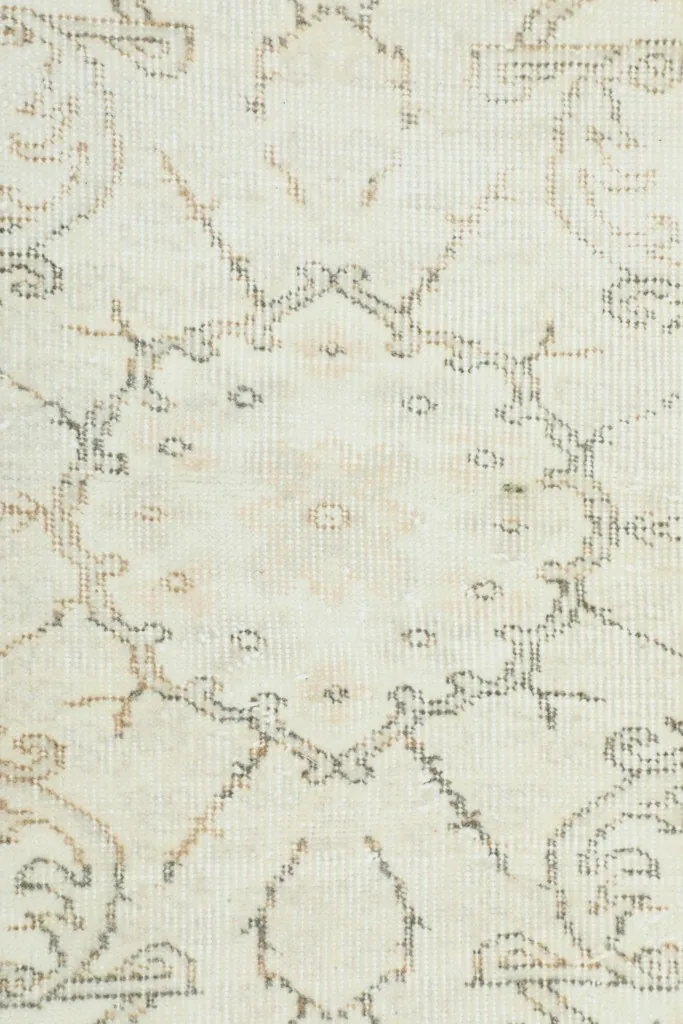 Close-up of the intricate, faded gray and tan geometric motifs within the rug's design