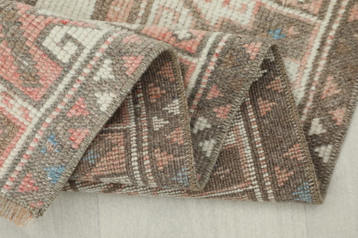 Close-up of the rug's edge and fringe, showing the natural wear and soft texture.