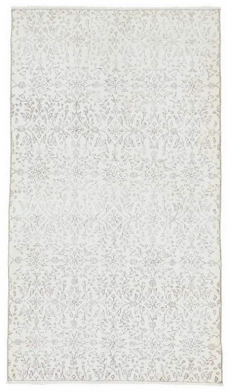 Full overhead view of the ivory and tan floral vintage Anatolian area rug on a white background.