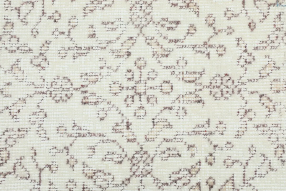 Extreme close-up of the low wool pile, revealing the hand-knotted texture and tan pattern.