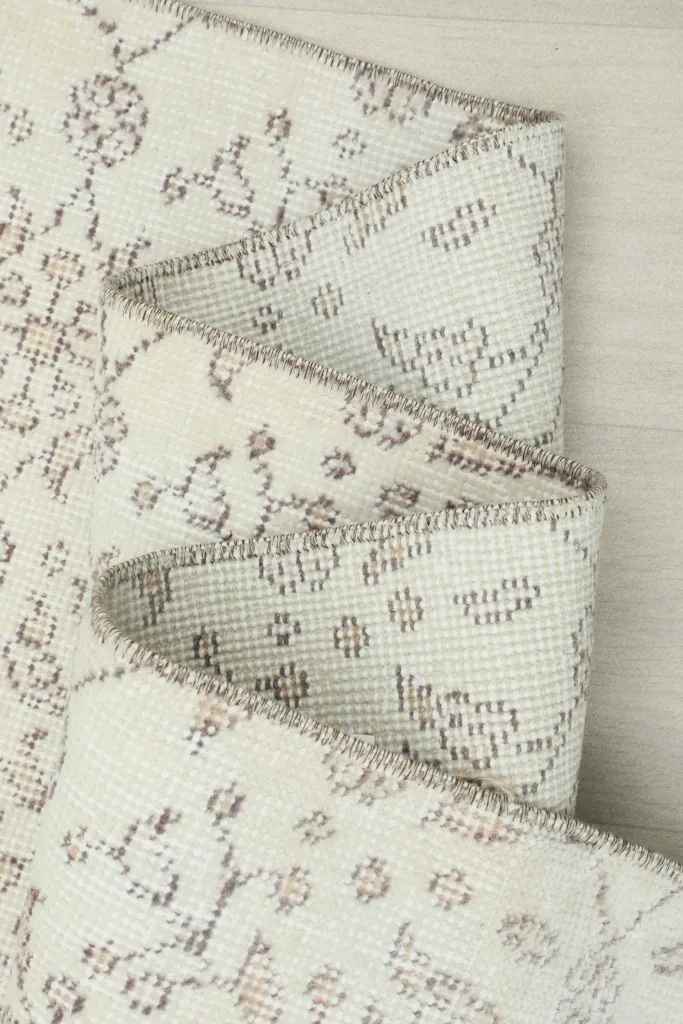 Rug folded multiple times, showcasing the thickness of the material and the intricate pattern.