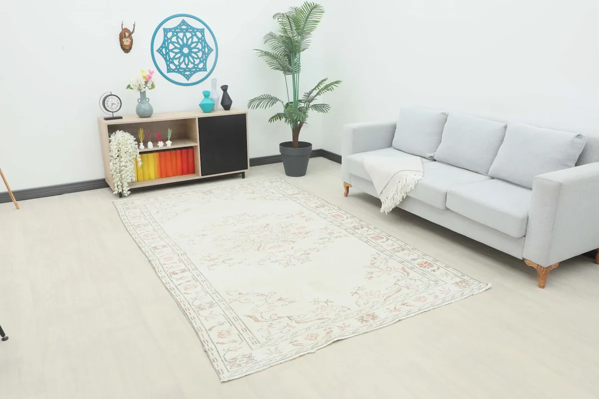 Vintage Anatolian rug displayed in a living room setting with a light gray sofa and modern decor.