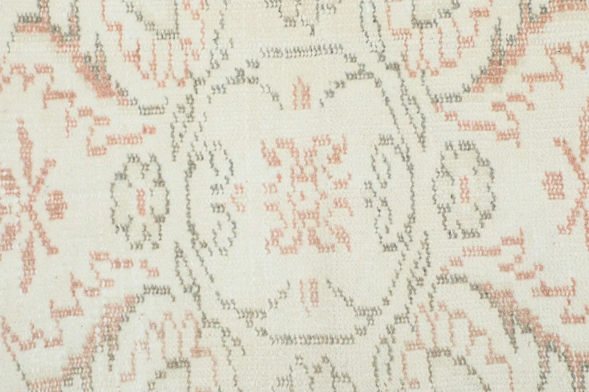 Detailed view of the hand-knotted wool pile, showing the intricate rose and gray patterns.