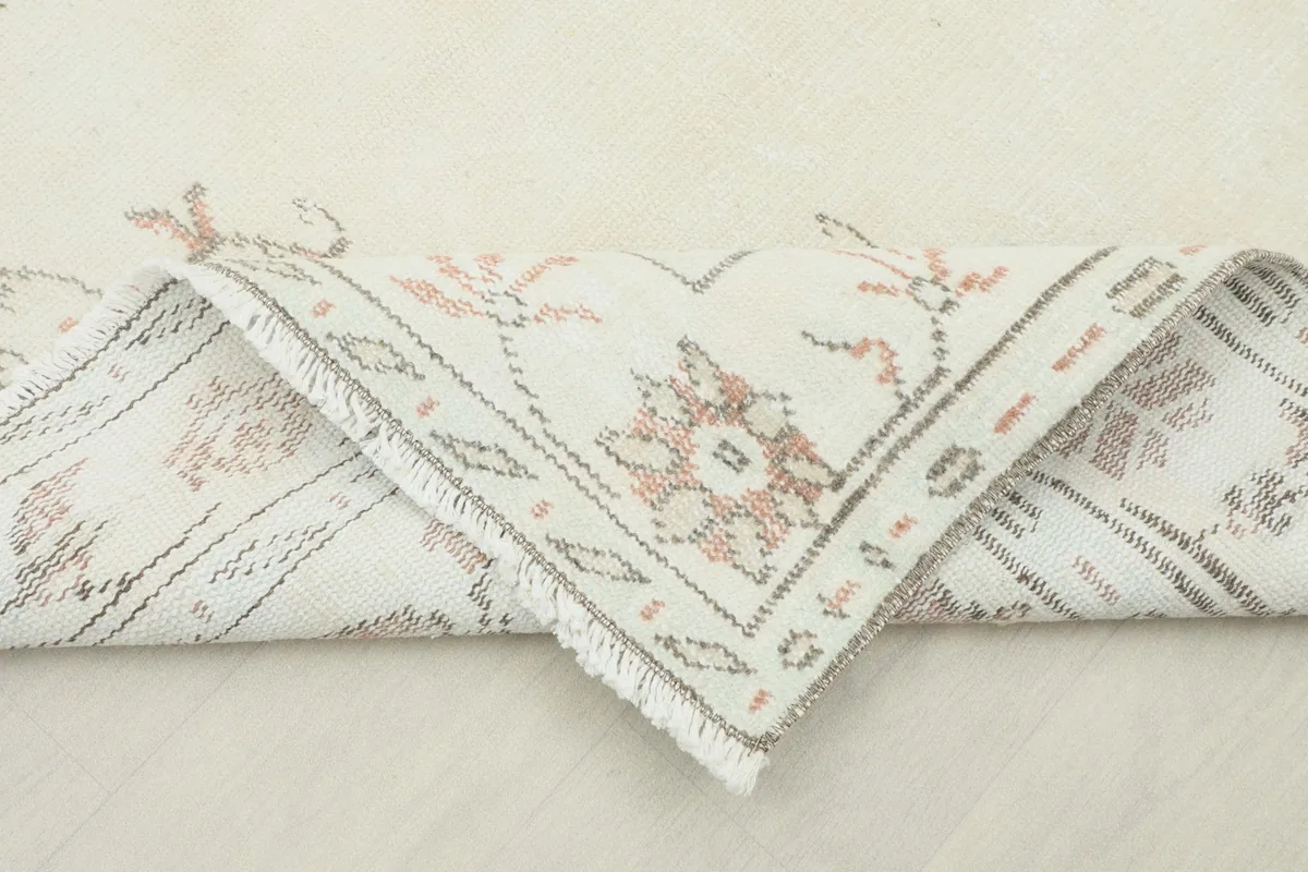 Folded corner of the rug, revealing the reverse side and the hand-knotted construction.