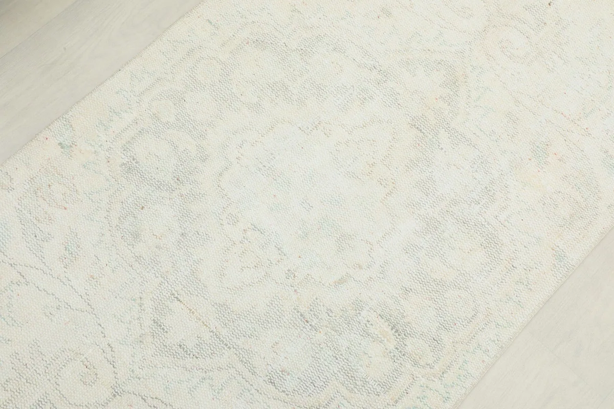 Close-up of the central medallion design, showing its faded appearance and light colors