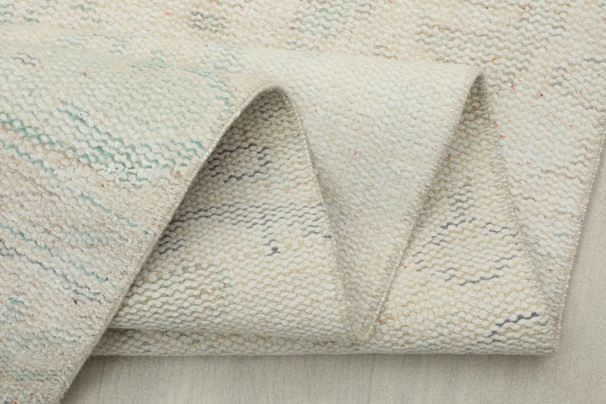 Close-up of the rug folded, showing the thickness and the back of the weave