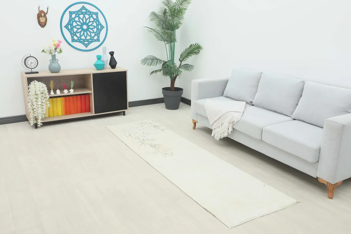 Vintage runner rug displayed in a modern living room setting next to a sofa and cabinet
