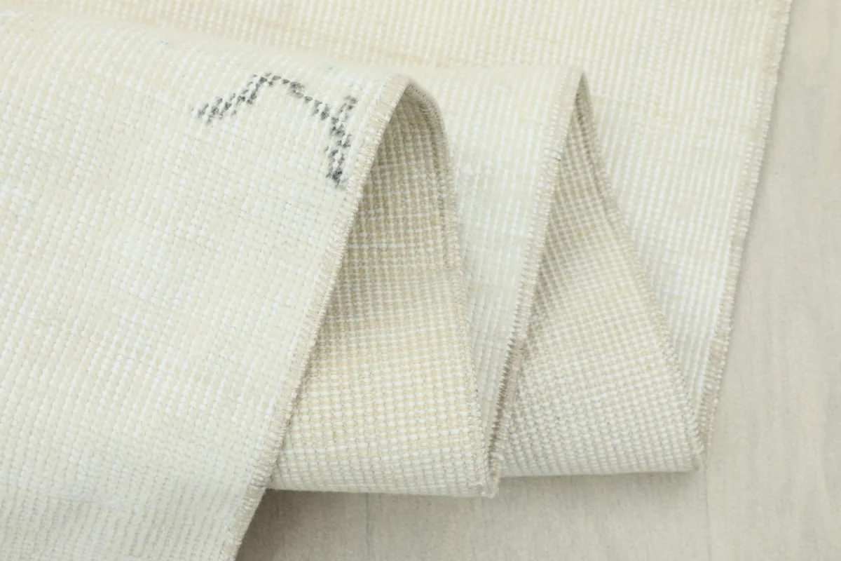 Close-up of the rug's fold, highlighting the tightly woven cotton foundation