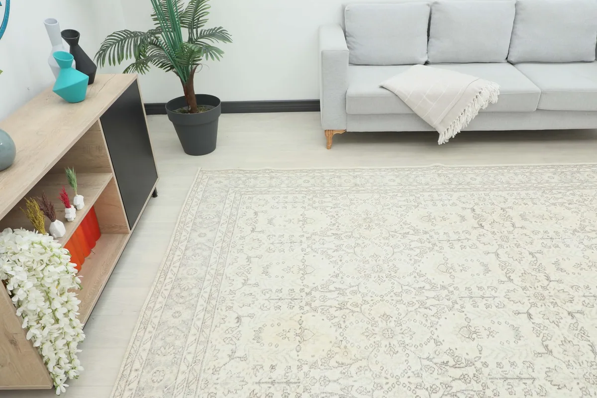 Angle view of the large ivory rug in a living room, showing its scale next to furniture