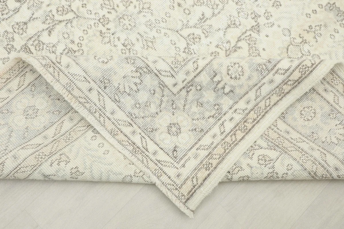 Folded corner of the rug, revealing the cotton foundation and reverse side of the hand-knotted wool