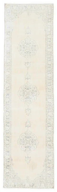 Full top view of an ivory and blue vintage Anatolian runner rug on a white background.